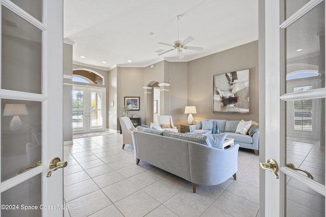 living room with ceiling fan, light tile patterned floors, crown molding, and french doors