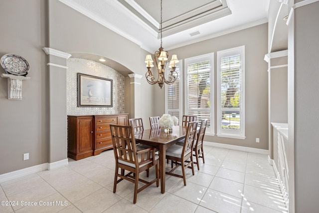 dining space featuring decorative columns, a raised ceiling, crown molding, light tile patterned floors, and a chandelier