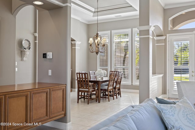 tiled dining area with a chandelier, a healthy amount of sunlight, a tray ceiling, and crown molding