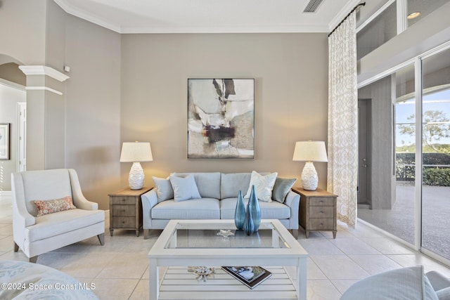 tiled living room featuring decorative columns and ornamental molding