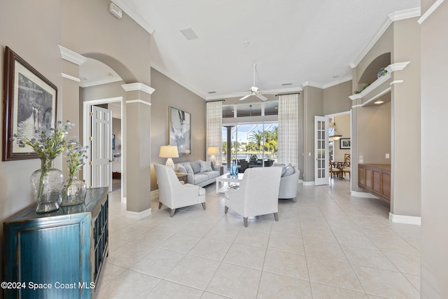 living room featuring french doors, ceiling fan, ornate columns, ornamental molding, and light tile patterned flooring