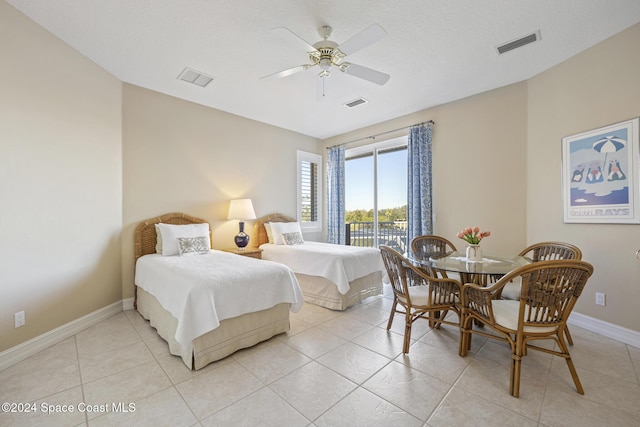 tiled bedroom featuring ceiling fan and a textured ceiling