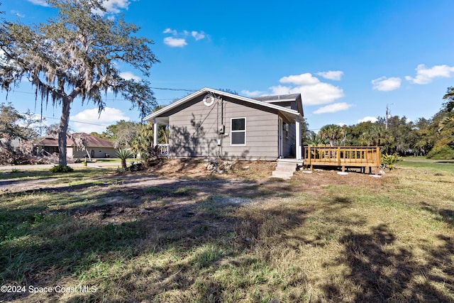 rear view of house featuring a deck and a yard