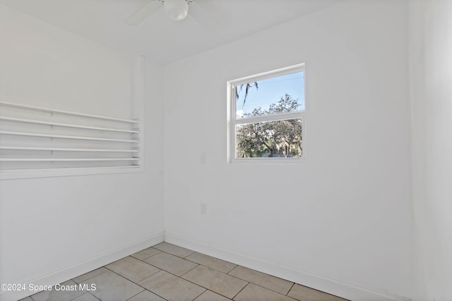 tiled empty room featuring ceiling fan