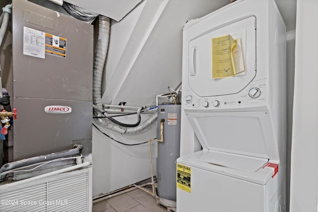 clothes washing area with stacked washer / dryer, water heater, and light tile patterned floors