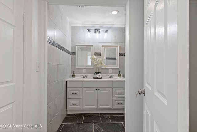 bathroom with vanity and tile walls