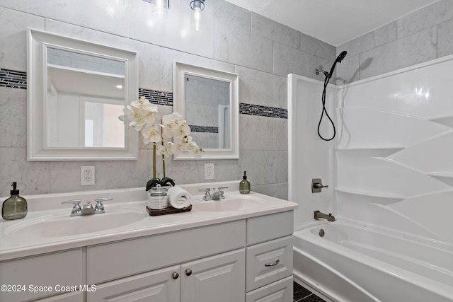 bathroom featuring shower / bathing tub combination, vanity, and tile walls