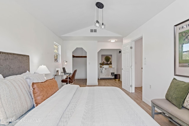 bedroom with vaulted ceiling and light wood-type flooring