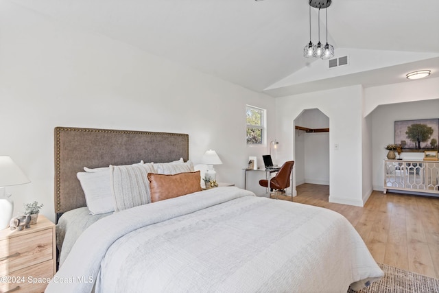 bedroom featuring light hardwood / wood-style flooring and lofted ceiling