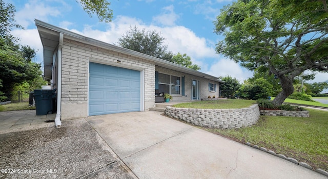 ranch-style house with a garage and a front lawn