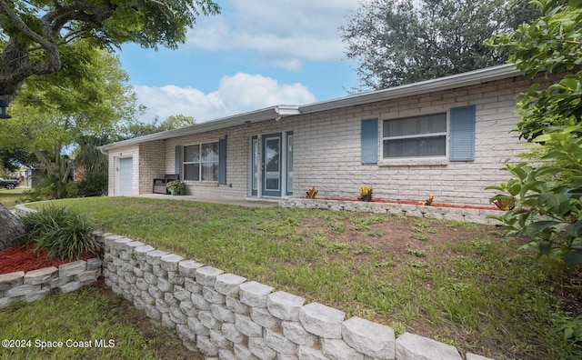 single story home featuring a front yard and a garage