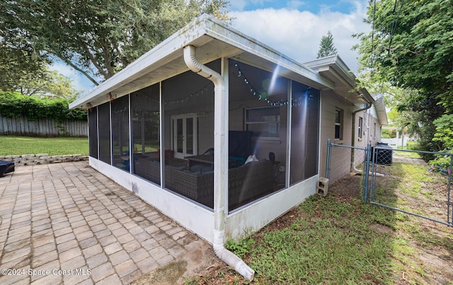 view of side of property featuring a sunroom and cooling unit