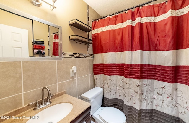 bathroom with a shower with shower curtain, vanity, a textured ceiling, tile walls, and toilet