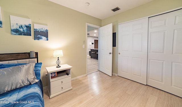 bedroom with light wood-type flooring and a closet