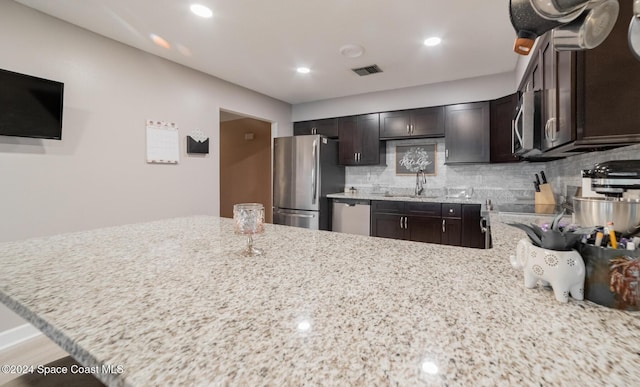 kitchen featuring dark brown cabinetry, kitchen peninsula, and appliances with stainless steel finishes