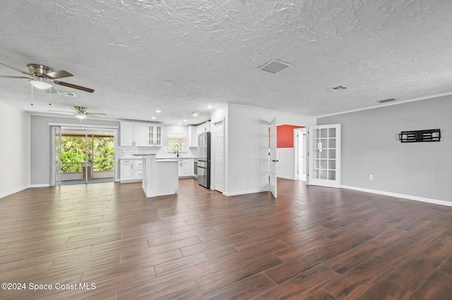 unfurnished living room featuring a textured ceiling, dark hardwood / wood-style flooring, ceiling fan, and sink