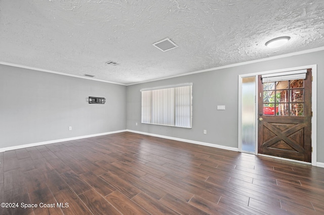 unfurnished room with dark hardwood / wood-style flooring, ornamental molding, and a textured ceiling