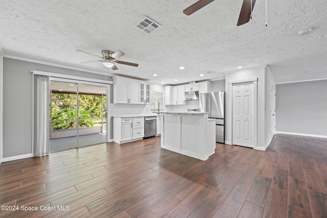 kitchen featuring appliances with stainless steel finishes, a textured ceiling, white cabinets, dark hardwood / wood-style floors, and a kitchen island