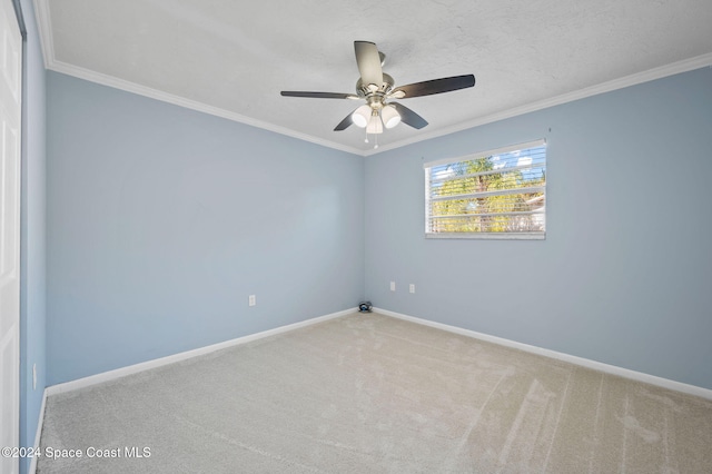 carpeted empty room featuring ceiling fan and ornamental molding