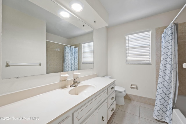 full bathroom with tile patterned floors, vanity, a healthy amount of sunlight, and toilet