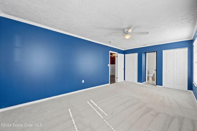 unfurnished bedroom with connected bathroom, ceiling fan, carpet floors, a textured ceiling, and ornamental molding