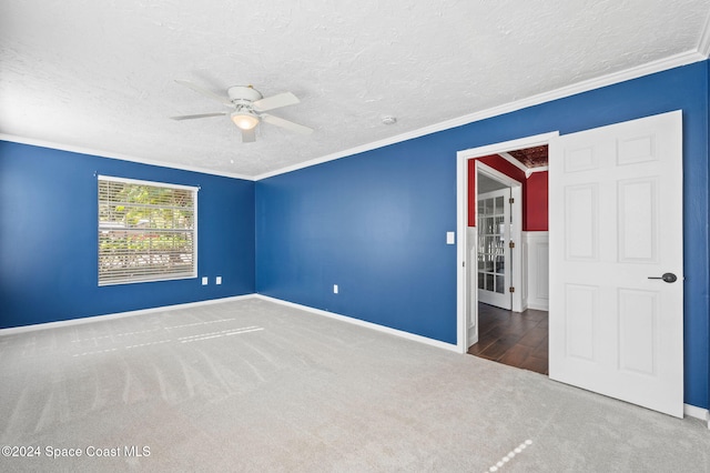 unfurnished bedroom featuring ceiling fan, carpet, a textured ceiling, and ornamental molding