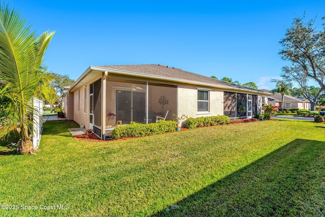 rear view of property featuring a lawn and a sunroom