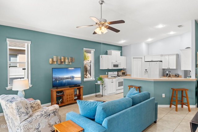 living room with sink, vaulted ceiling, ceiling fan, and light tile patterned floors