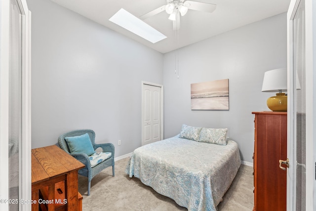 bedroom with lofted ceiling with skylight, a closet, and ceiling fan