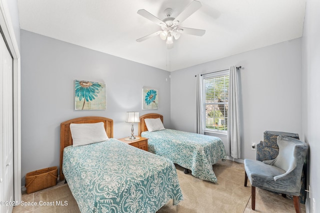 bedroom with ceiling fan, light colored carpet, and a closet