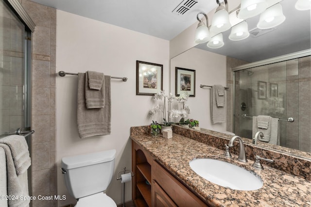 bathroom featuring toilet, an enclosed shower, and vanity