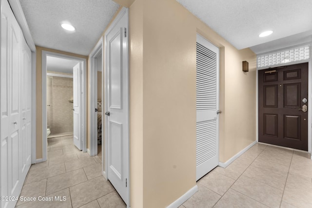 hallway featuring light tile patterned floors and a textured ceiling