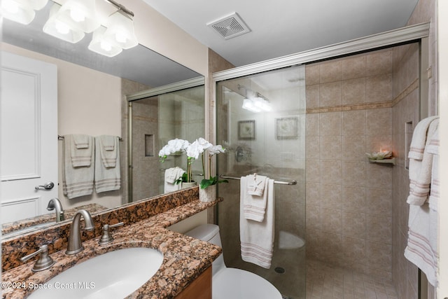 bathroom with vanity, an enclosed shower, and toilet