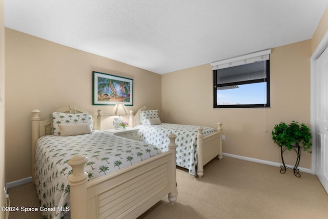 bedroom with a textured ceiling and light colored carpet