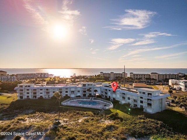 aerial view at dusk featuring a water view