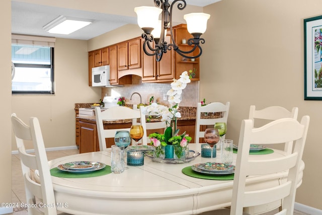 dining space with light tile patterned floors and a chandelier