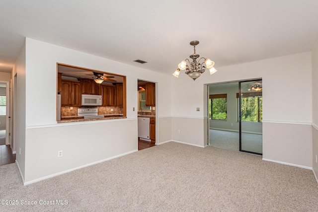 unfurnished living room featuring ceiling fan with notable chandelier and light carpet