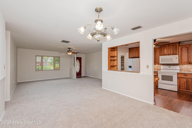 unfurnished living room with ceiling fan with notable chandelier and dark colored carpet