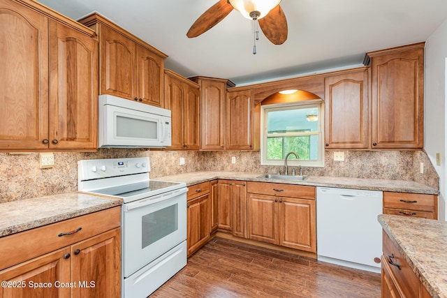 kitchen featuring dark hardwood / wood-style flooring, light stone counters, white appliances, ceiling fan, and sink