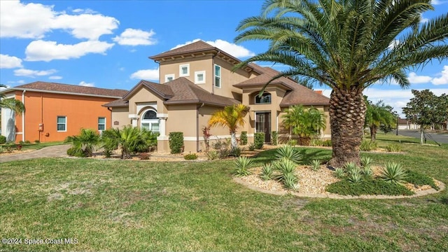 mediterranean / spanish home featuring a front lawn