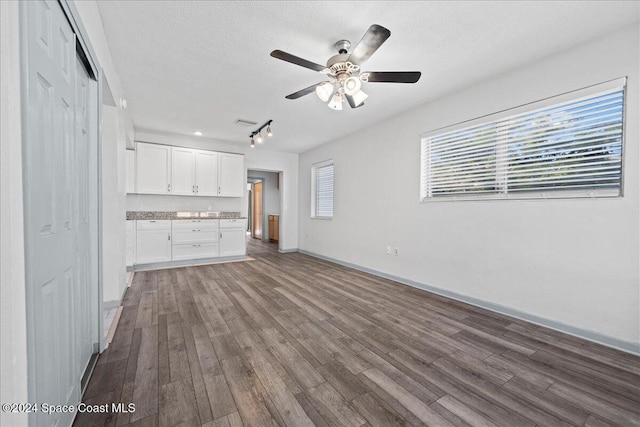 unfurnished living room with hardwood / wood-style flooring, ceiling fan, and a textured ceiling