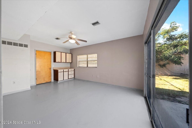 unfurnished living room featuring concrete floors and ceiling fan