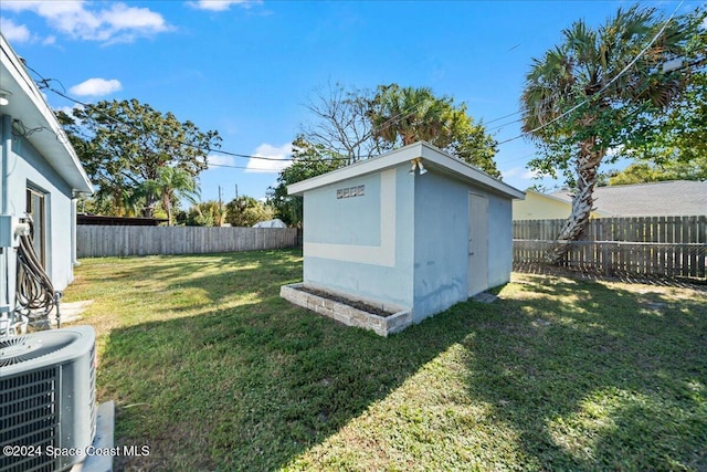 view of yard with central AC unit and a storage shed