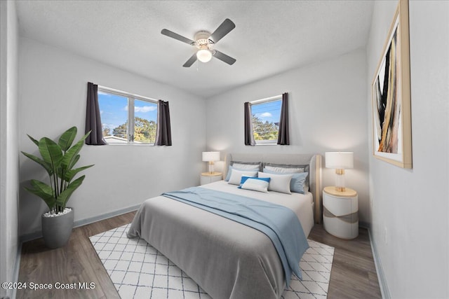 bedroom featuring a textured ceiling, light wood-type flooring, and ceiling fan