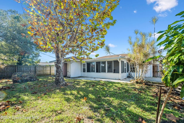 rear view of property with a sunroom and a lawn