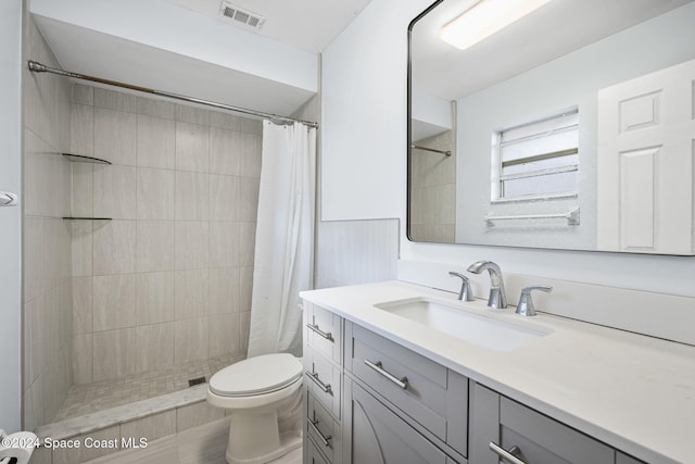 bathroom featuring vanity, curtained shower, and toilet