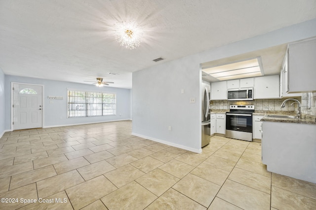 kitchen featuring backsplash, stainless steel appliances, ceiling fan, sink, and white cabinets