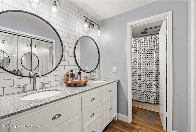 bathroom featuring vanity, backsplash, hardwood / wood-style flooring, a textured ceiling, and curtained shower