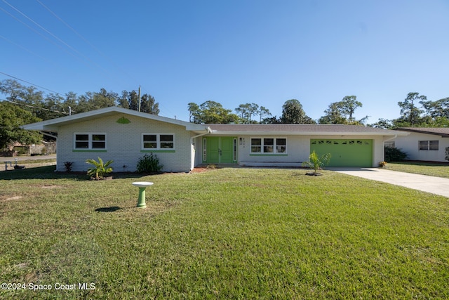 8303 Sylvan Dr, Melbourne, FL 32904 - ranch-style house with concrete driveway, an attached garage, a front lawn, and brick siding