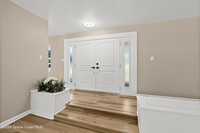 entrance foyer featuring hardwood / wood-style floors, a textured ceiling, and a healthy amount of sunlight